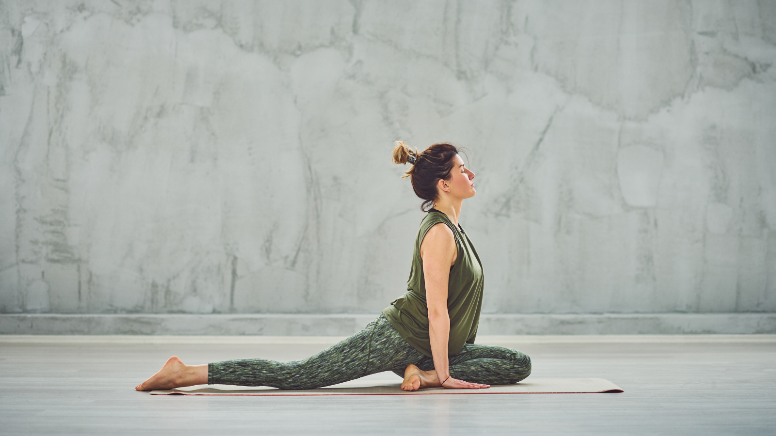 Pigeon Pose is a not always suitable for all body types Brunette yogi doing Half Pigeon yoga pose a hip opening and not recommended for all bodies pose