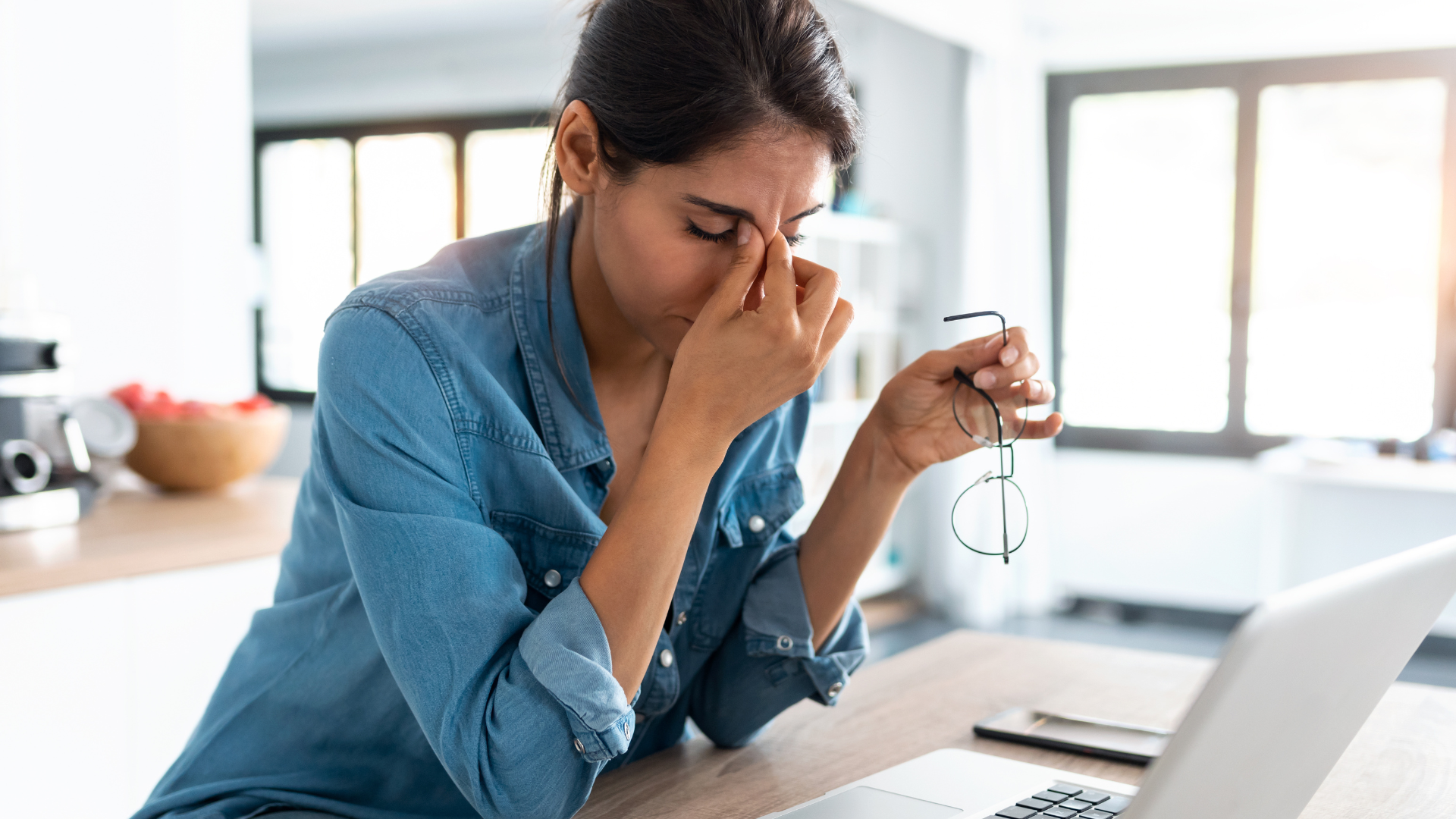 Stress can inhibit the person's ability to develop interoception. Shot of stressed business woman working from home on laptop looking worried, tired and overwhelmed.