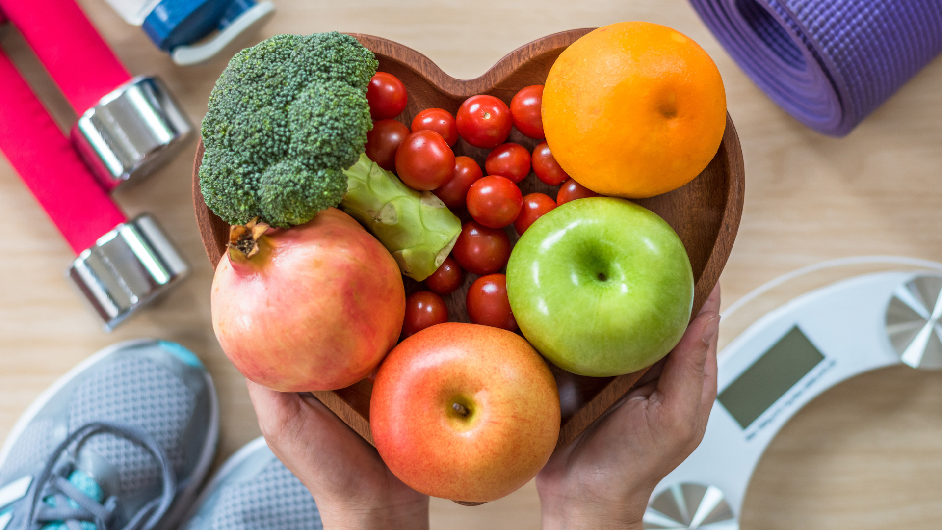 Treating sleep apnea, exercise, healthy food all contribute to a healthy heart. Healthy lifestyle concept, clean food in heart dish also with aerobic body exercise, workout equipment, weight scale and sports shoes in fitness center.