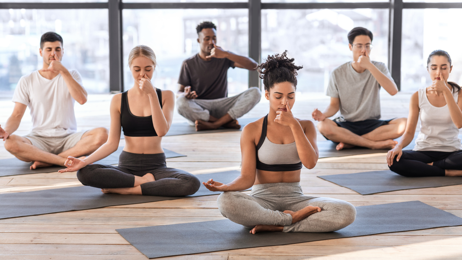 How to slow down the exhalation in pranayama breathing in yoga class to balance the vagus nerve Yoga students in class practicing pranayama breathing to stimulate and balance the vagus nerve and relax