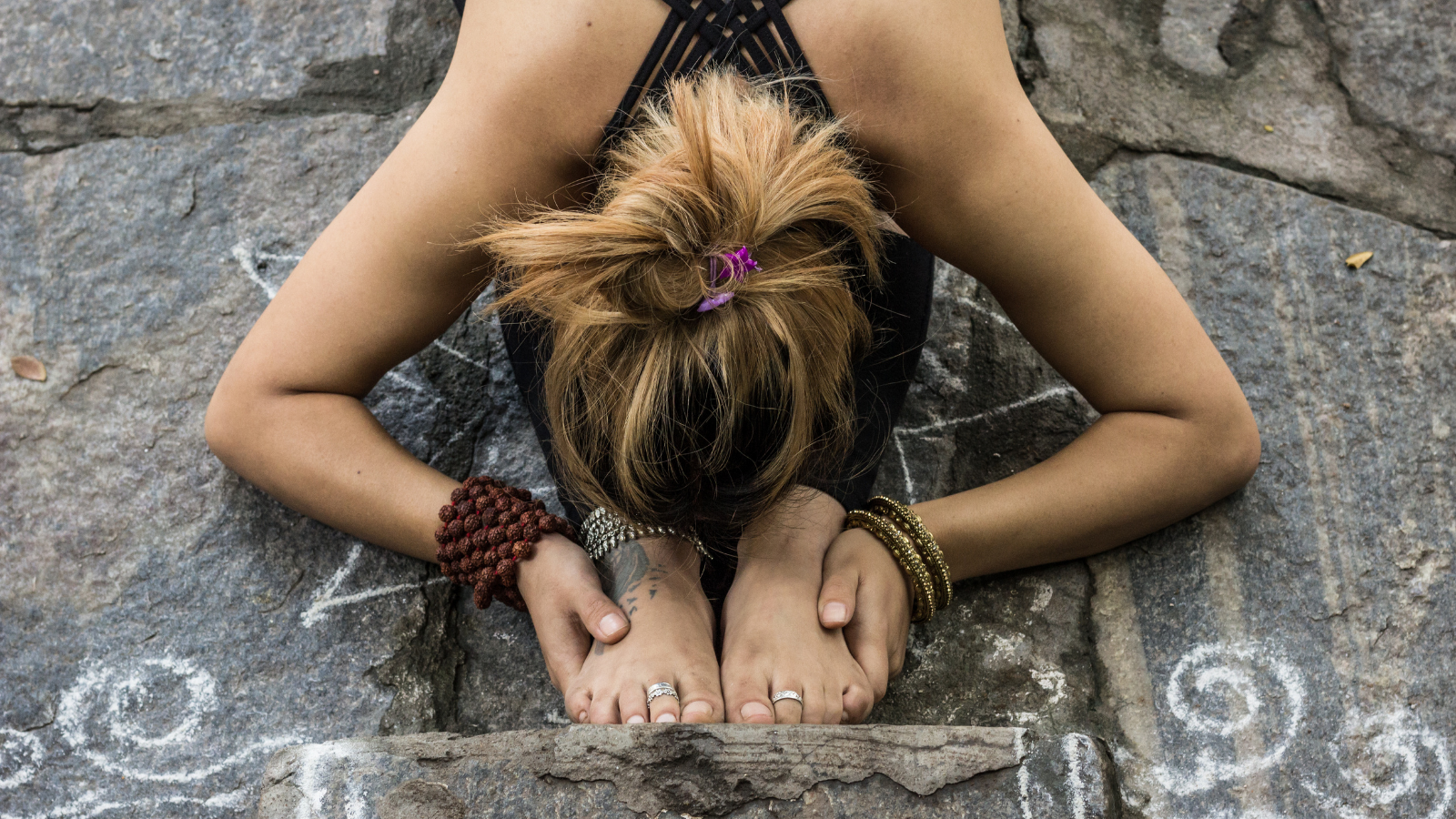 How to practice forward folds to experience grief and other stresses to help release that trauma Woman practicing a deep forward fold or Paschimottanasana with conscious breathing