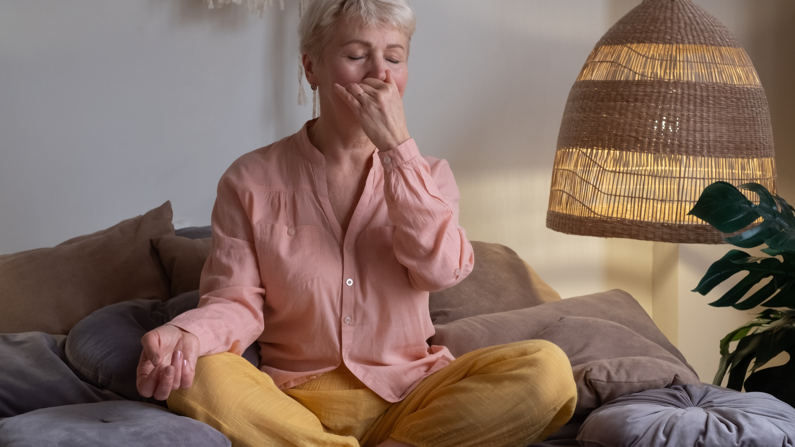 How to practice Alternate Nostril Breathing and calming meditation to settle the mind and body. Senior woman practicing Alternate Nostril Breathing exercise, Nadi Shodhana Pranayama at home.