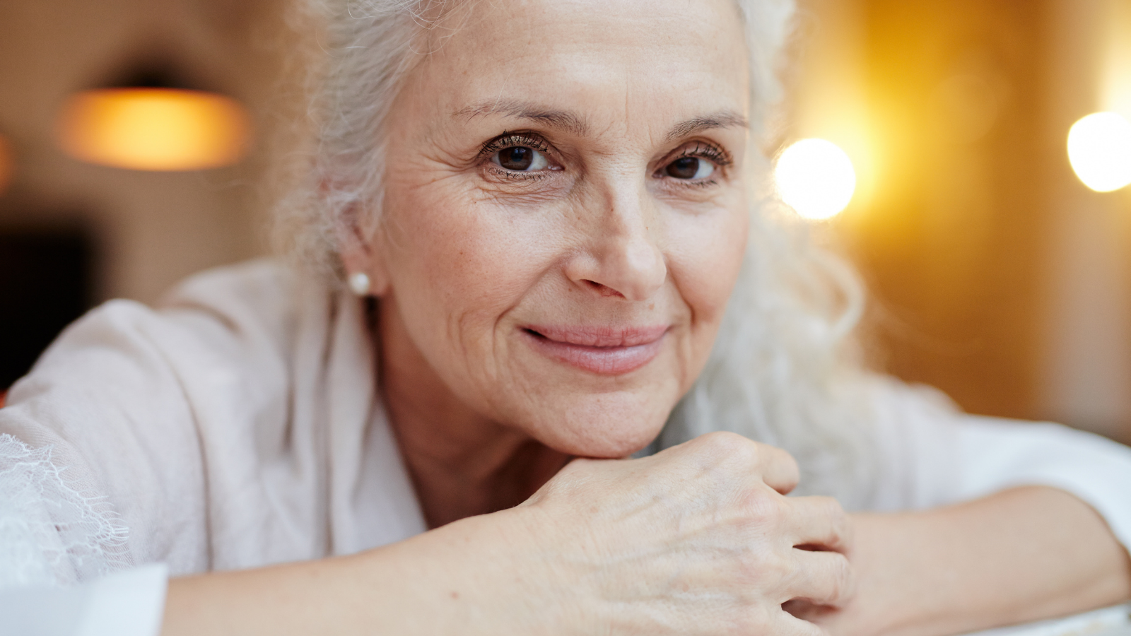 Practicing yoga for the many many physical and mental health benefits Happy grey-haired female yogini smiling at camera