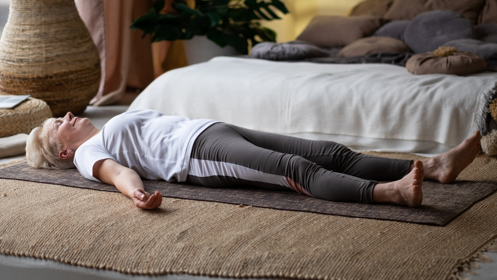 Savasana Pose as preparation for good sleep Senior woman lying on yoga mat after workout