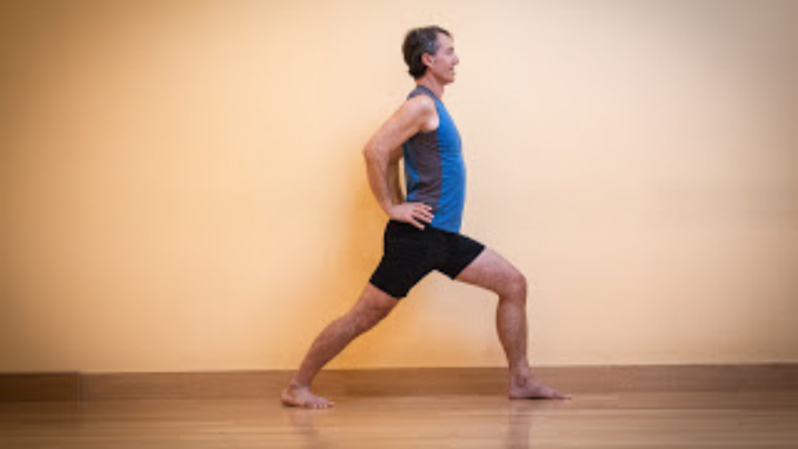 Warrior 1 or Virabhadrasana 1 Pose with hands on hips.